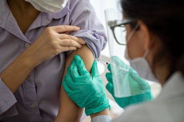 Genç bayan, aşı için yetenekli doktoru hastanede ziyaret ediyor.