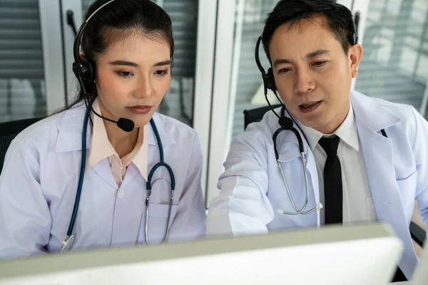 Team di medici con auricolari che parlano attivamente in videochiamata in clinica ospedaliera — Foto Stock