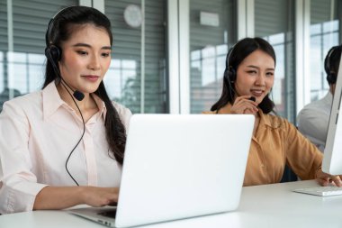 Kulaklık takan iş adamları ofiste aktif olarak çalışıyorlar.