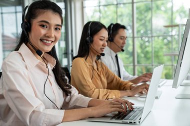 Kulaklık takan iş adamları ofiste aktif olarak çalışıyorlar.