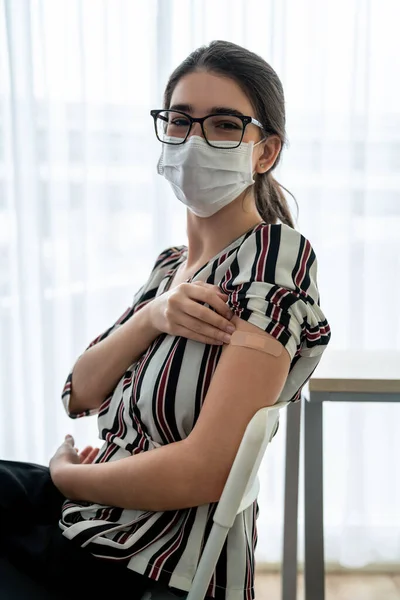 Junge Frau zeigt fröhlich COVID-19 Impfverband — Stockfoto