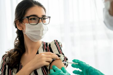Genç bayan, aşı için yetenekli doktoru hastanede ziyaret ediyor.