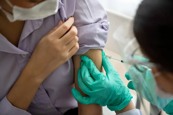 Молодая женщина посещает опытного врача в больнице для вакцинации — стоковое фото