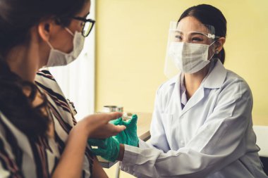 Genç bayan, aşı için yetenekli doktoru hastanede ziyaret ediyor.