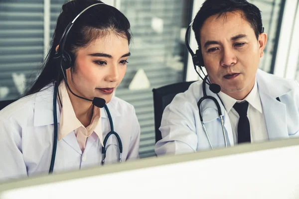 Doctor team wearing headset talking actively on video call in hospital clinic — Stock Photo, Image