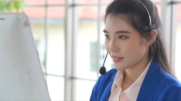 Businesswoman wearing headset working actively in office — Stock Photo, Image