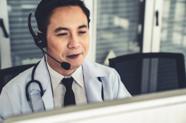 Kulaklık takan doktor klinikte ya da hastanede aktif olarak konuşuyor. .