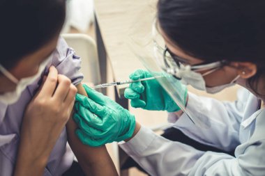 Genç bayan, aşı için yetenekli doktoru hastanede ziyaret ediyor.