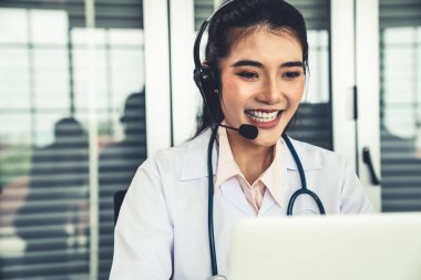 Kulaklık takan doktor hastane ya da klinikteki video konuşmasında aktif olarak konuşuyor.