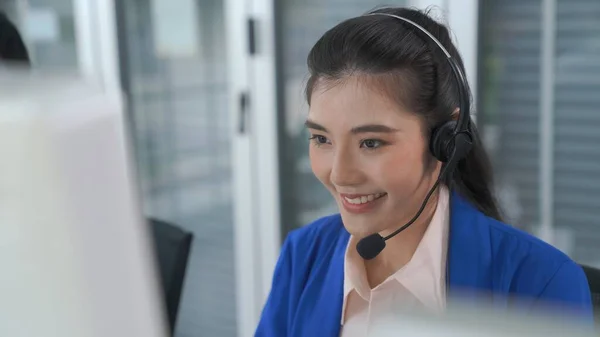 Empresaria con auriculares trabajando activamente en la oficina — Foto de Stock