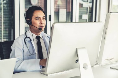 Kulaklık takan doktor klinikte ya da hastanede aktif olarak konuşuyor. .