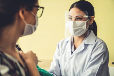 Genç bayan, aşı için yetenekli doktoru hastanede ziyaret ediyor.