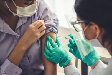 Genç bayan, aşı için yetenekli doktoru hastanede ziyaret ediyor.