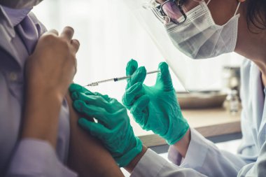 Genç bayan, aşı için yetenekli doktoru hastanede ziyaret ediyor.