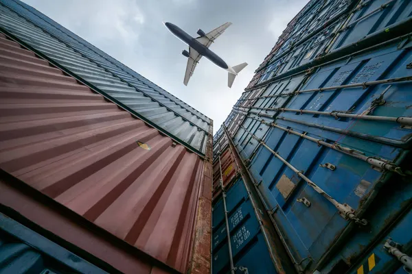 Nákladní letadlo letící nad zámořským kontejnerem — Stock fotografie