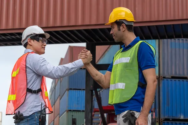 Trabalhador industrial trabalha com colega de trabalho no pátio de contêineres de transporte no exterior — Fotografia de Stock