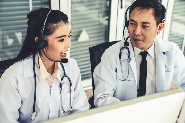 Equipo médico que usa auriculares hablando activamente en videollamada en la clínica del hospital — Foto de Stock