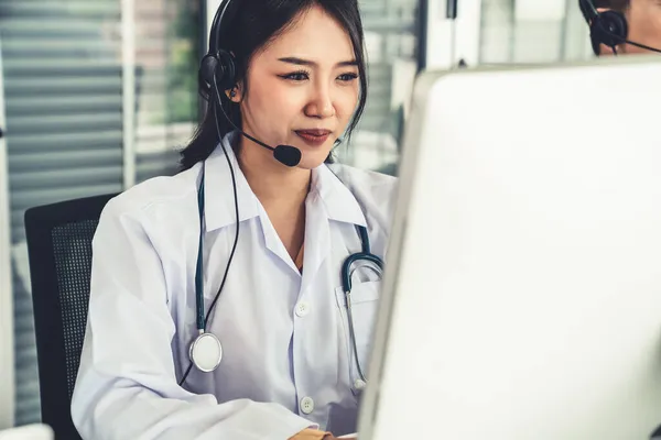 Medico indossando auricolare parlando attivamente in videochiamata in ospedale o in clinica — Foto Stock