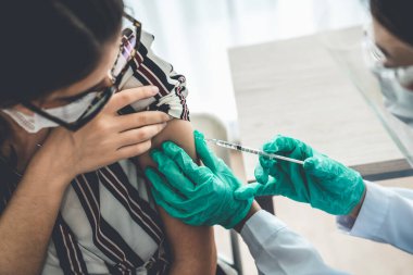 Genç bayan, aşı için yetenekli doktoru hastanede ziyaret ediyor.