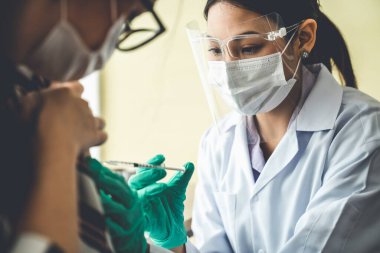 Genç bayan, aşı için yetenekli doktoru hastanede ziyaret ediyor.