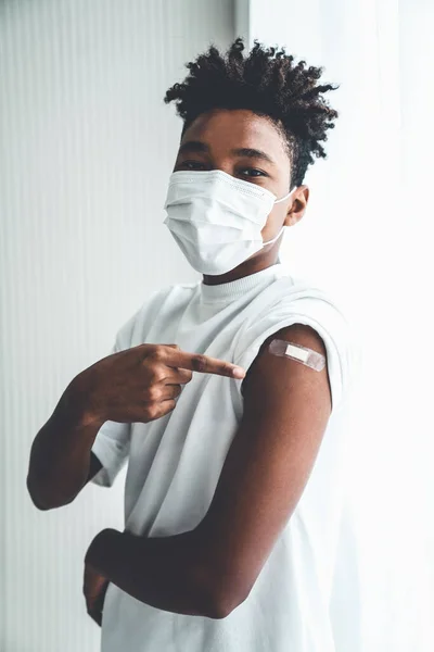 Adolescent afro-américain montrant joyeusement le bandage de vaccin COVID-19 — Photo