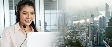 Ofis çalışanı kulaklık takıyor ve ofiste çalışıyor.