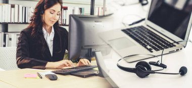Ofiste çalışan kulaklık takan işadamları uzak müşteri ya da meslektaşlarını desteklemek için çalışıyorlar. Çağrı merkezi, tele pazarlama, müşteri destek acentesi geniş görünümde hizmet sunar .