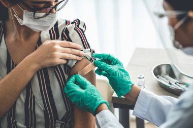 Genç bayan, aşı için yetenekli doktoru hastanede ziyaret ediyor.
