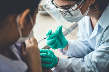 Genç bayan, aşı için yetenekli doktoru hastanede ziyaret ediyor.