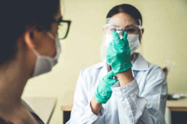 Genç bayan, aşı için yetenekli doktoru hastanede ziyaret ediyor.