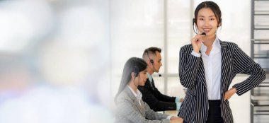 Ofiste çalışan kulaklık takan işadamları uzak müşteri ya da meslektaşlarını desteklemek için çalışıyorlar. Çağrı merkezi, tele pazarlama, müşteri destek acentesi geniş görünümde hizmet sunar .