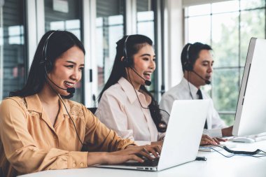 Kulaklık takan iş adamları ofiste aktif olarak çalışıyorlar.