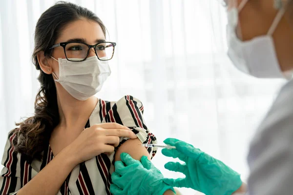 Молодая женщина посещает опытного врача в больнице для вакцинации — стоковое фото