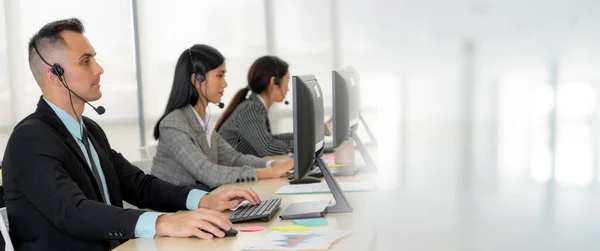 Zakenmensen die een headset dragen en op kantoor werken, verbreden het zicht — Stockfoto