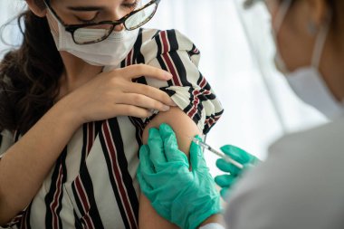 Genç bayan, aşı için yetenekli doktoru hastanede ziyaret ediyor.