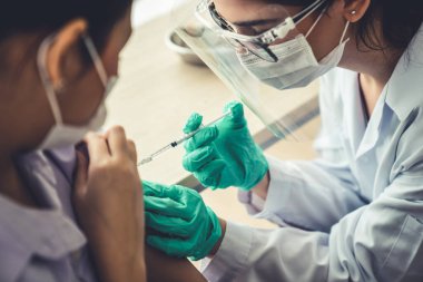 Genç bayan, aşı için yetenekli doktoru hastanede ziyaret ediyor.