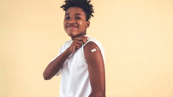 Africká americká teenager ukazuje COVID-19 vakcinační obvaz vesele — Stock fotografie