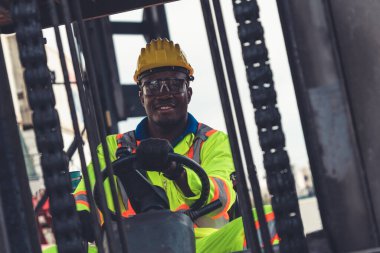 Tersanede forklift kullanan Afrikalı Amerikalı bir adam.