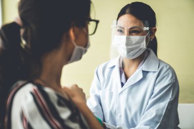 Genç bayan, aşı için yetenekli doktoru hastanede ziyaret ediyor.