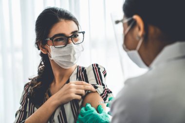 Genç bayan, aşı için yetenekli doktoru hastanede ziyaret ediyor.