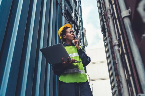 Denizaşırı nakliye konteynerinde çalışan genç Afrikalı Amerikalı kadın.