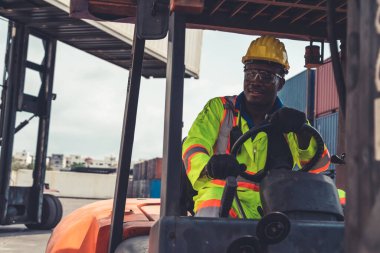 Tersanede forklift kullanan Afrikalı Amerikalı bir adam.
