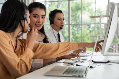 Kulaklık takan iş adamları ofiste aktif olarak çalışıyorlar.