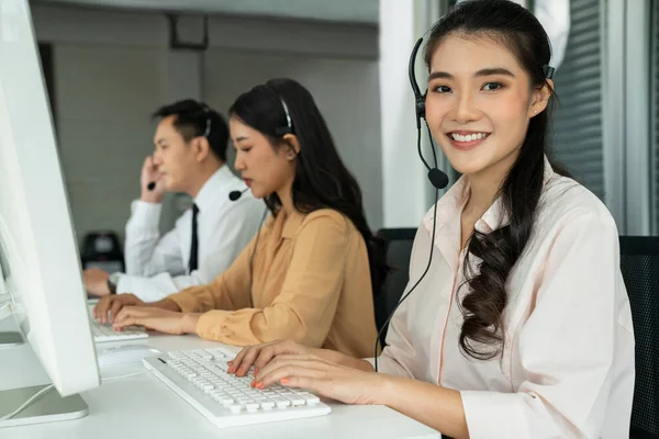 Επιχειρηματίες που φορούν ακουστικά και εργάζονται ενεργά στο γραφείο — Φωτογραφία Αρχείου