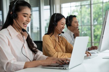 Kulaklık takan iş adamları ofiste aktif olarak çalışıyorlar.