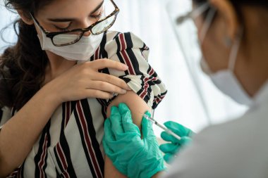 Genç bayan, aşı için yetenekli doktoru hastanede ziyaret ediyor.