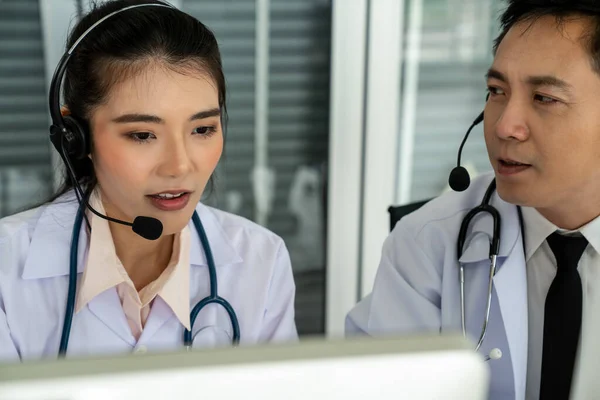 Team di medici con auricolari che parlano attivamente in videochiamata in clinica ospedaliera — Foto Stock
