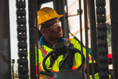 Tersanede forklift kullanan Afrikalı Amerikalı bir adam.