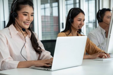 Kulaklık takan iş adamları ofiste aktif olarak çalışıyorlar.