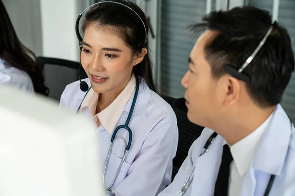 Equipo médico que usa auriculares hablando activamente en videollamada en la clínica del hospital — Foto de Stock